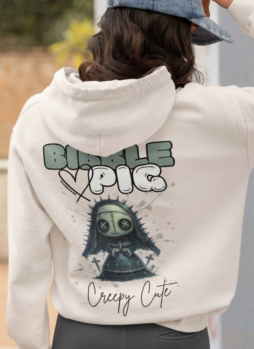 Model wearing eco heather oversized hoodie featuring Nightshade Nun Voodoo doll graphic and bold Bibble Pig Logo.  