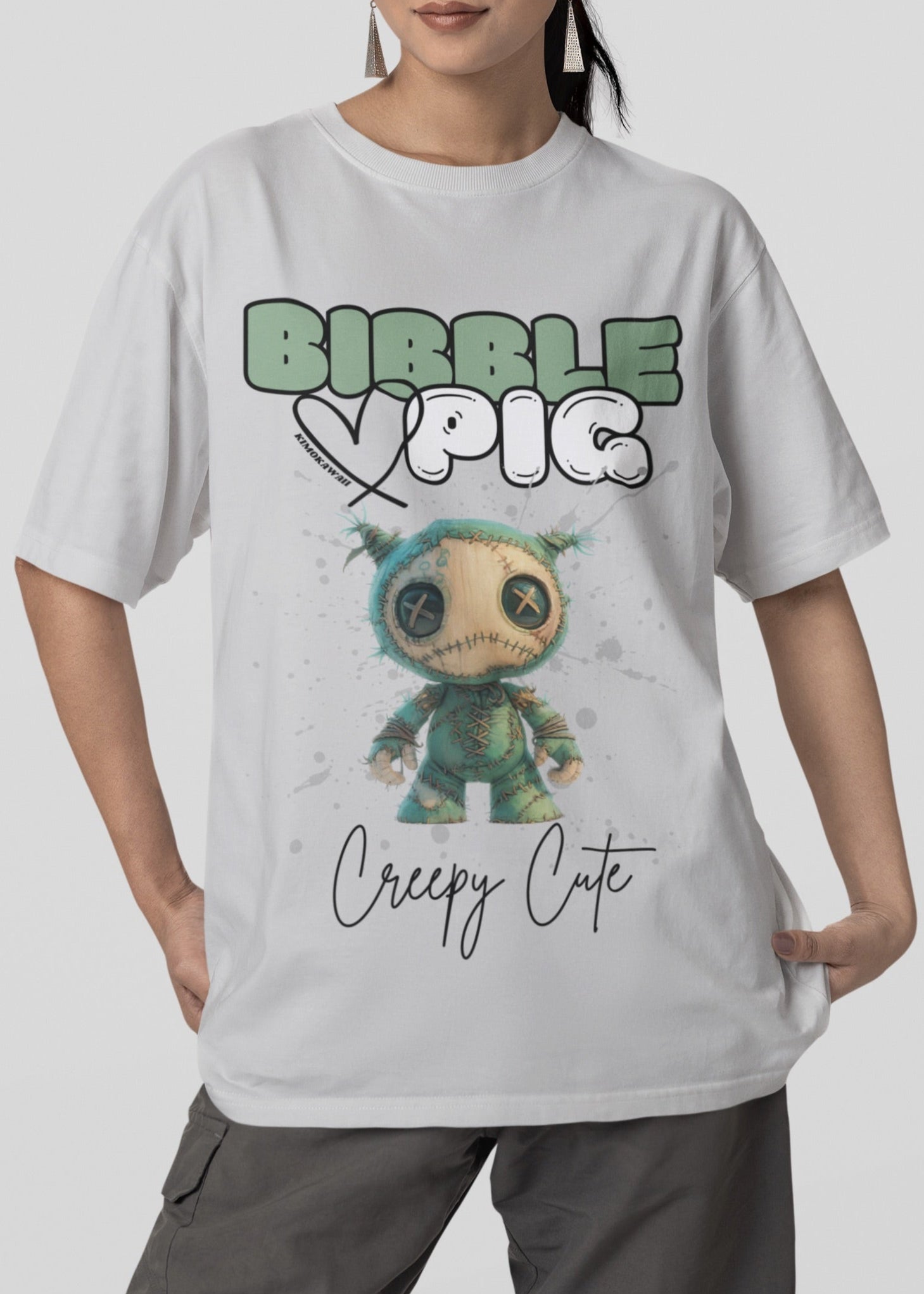 Close up view of model wearing grey oversized t-shirt featuring Night Terror Voodoo doll graphic and bold Bibble Pig Logo.