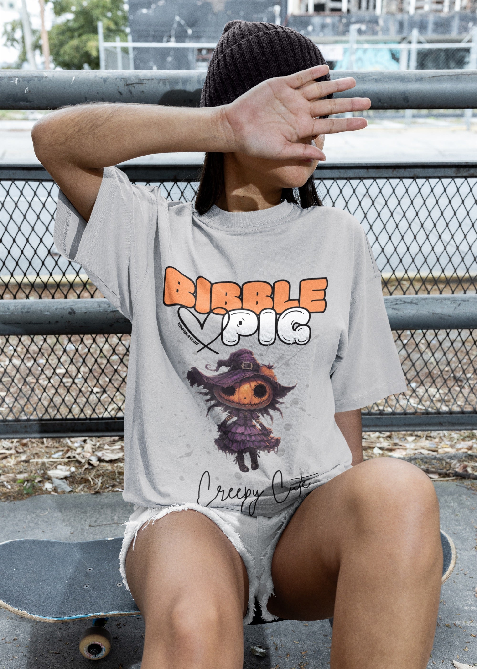 Model wearing grey oversized t-shirt featuring Pumpkin Willow Voodoo doll graphic and bold Bibble Pig Logo. 