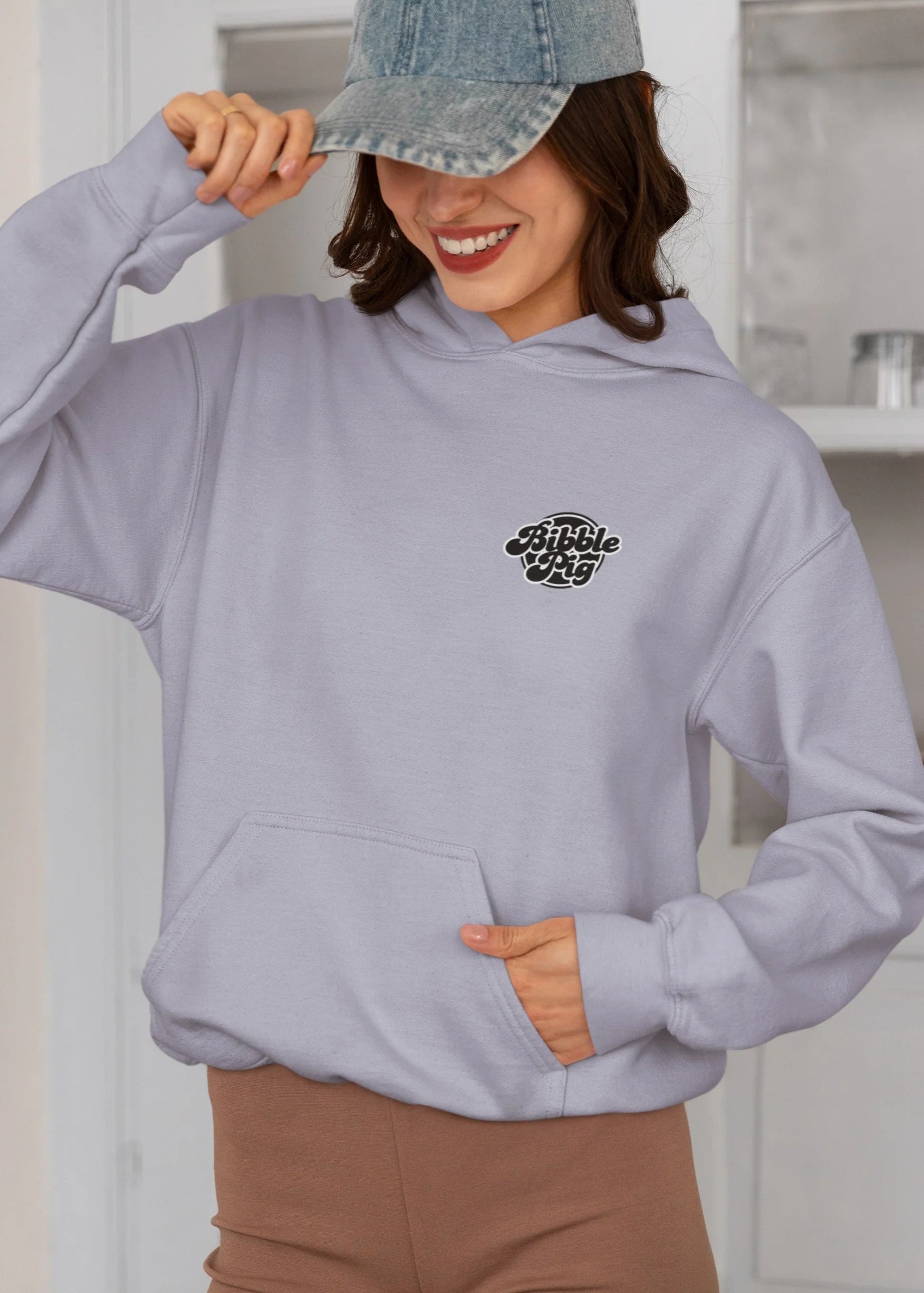Model wearing a grey oversized organic hoodie with our Lavender Bold Logo and cute heart design.    