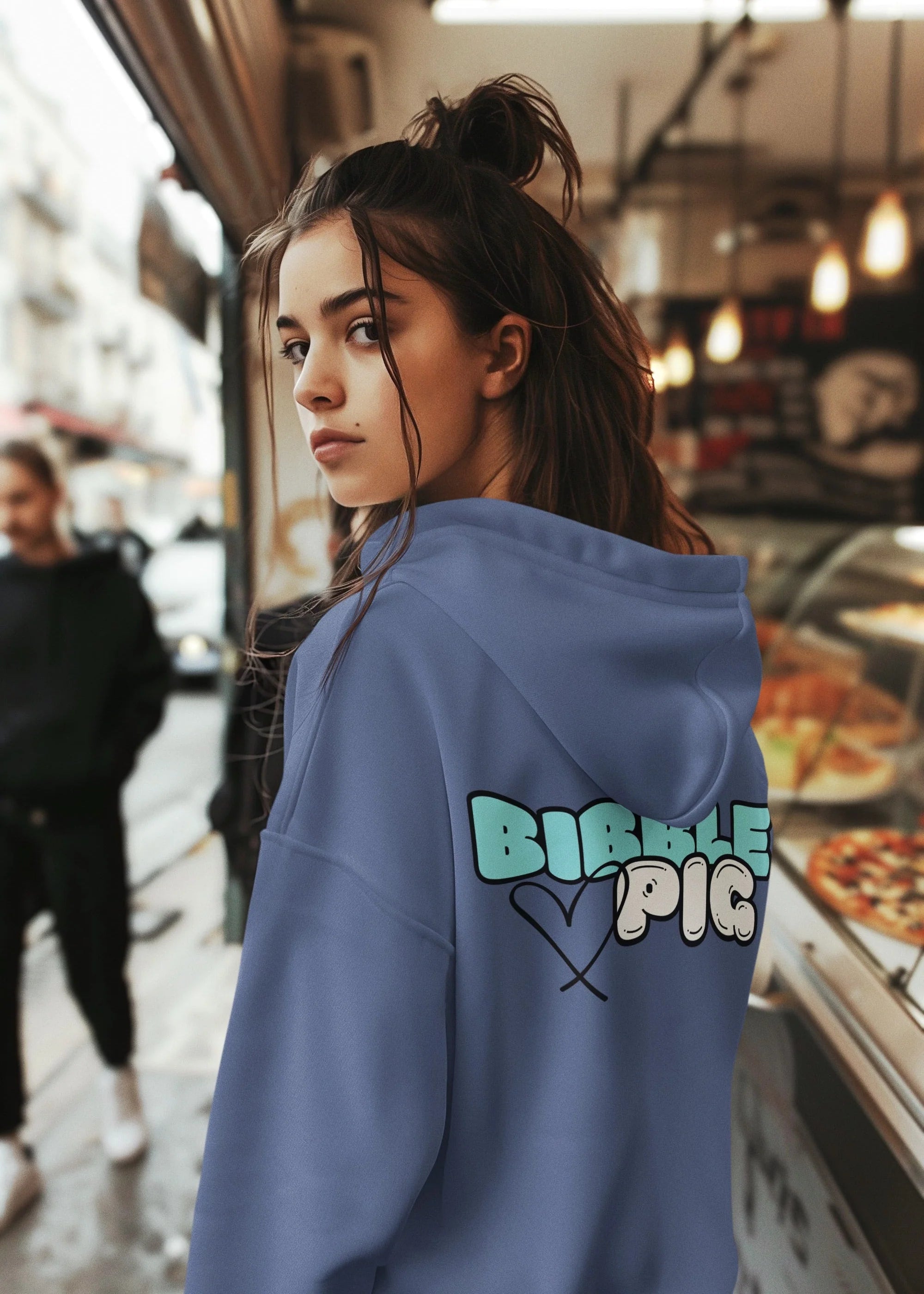Model wearing a blue oversized organic hoodie with our Pastel Blue Bold Logo and cute heart design. 