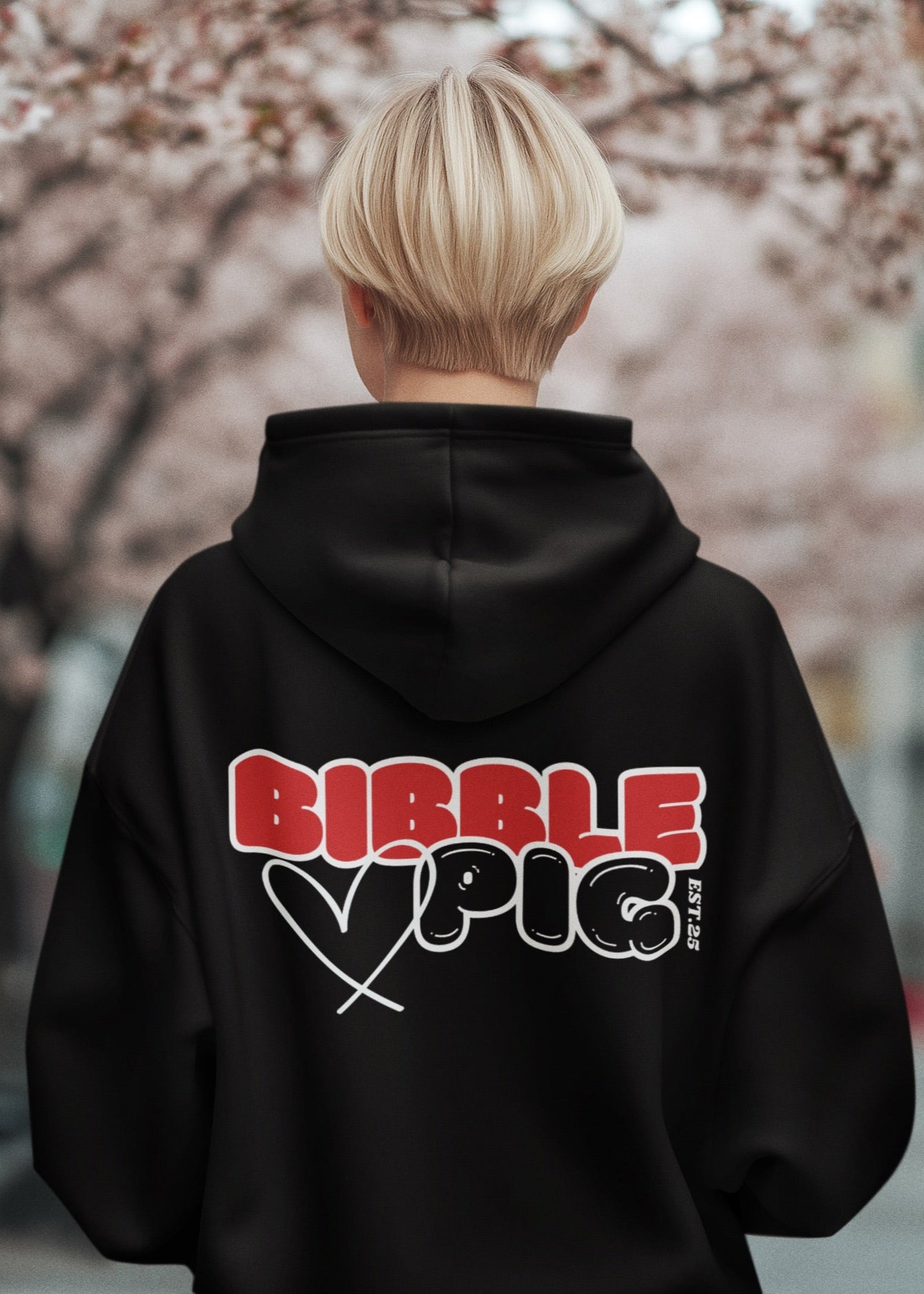 Model wearing a black oversized organic hoodie with our Red and Black Bold Logo and cute heart design.  