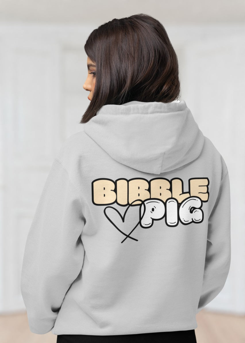 Model wearing a grey oversized organic hoodie with our Vanilla Bold Logo and cute heart design.  