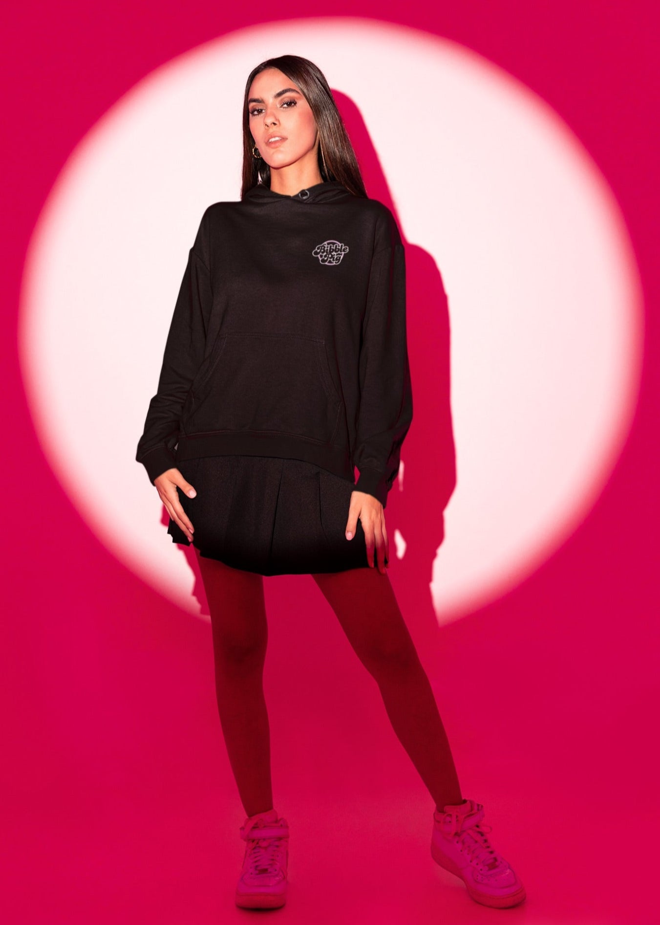 Front view of model wearing a black oversized organic hoodie with our White Bubblegum Bold Logo.