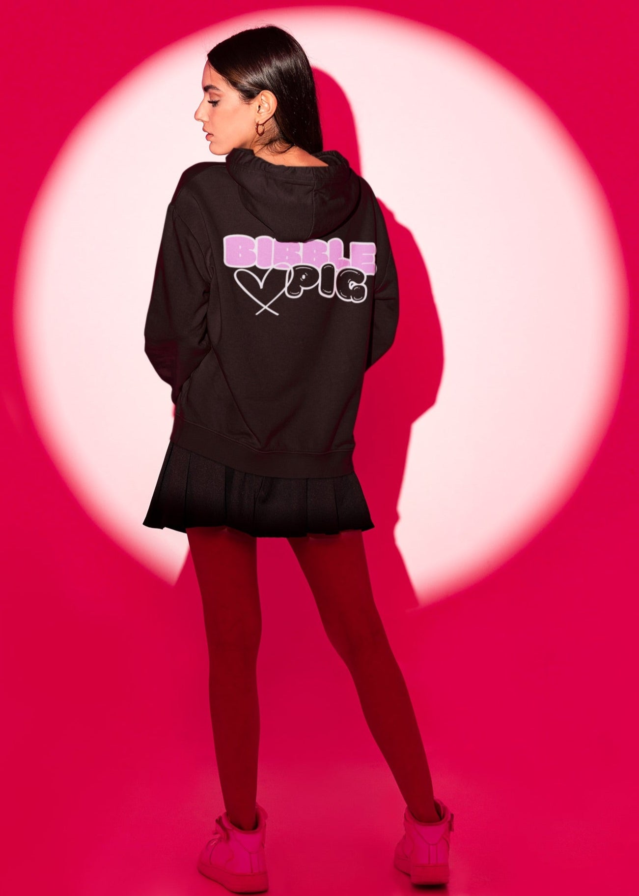 Model wearing a black oversized organic hoodie with our White Bubblegum Bold Logo and cute heart design. 