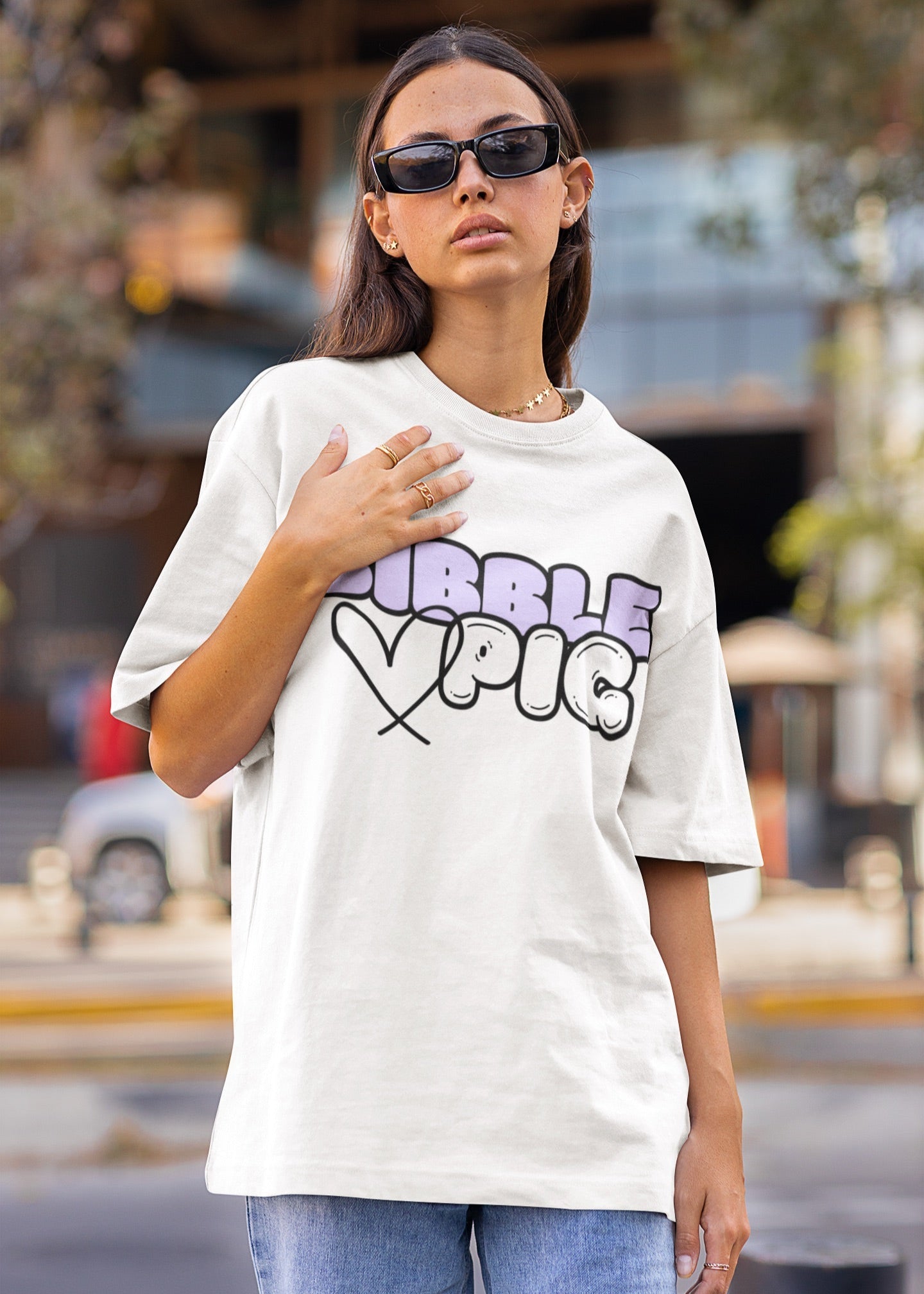 Close up of a model wearing a white oversized organic t-shirt with large Lavender Bold Logo and cute heart design.    