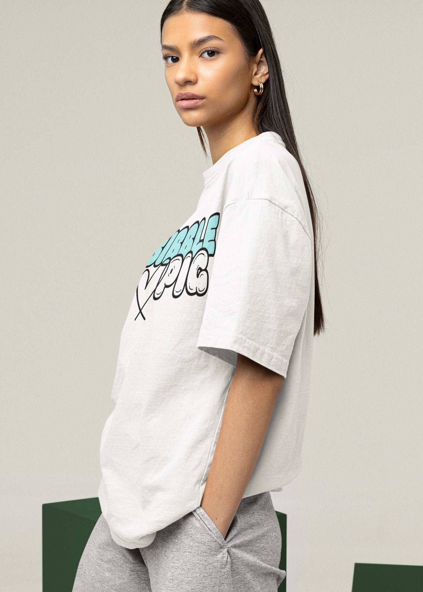 Model wearing Bibble Pig oversized organic cotton t shirt with pastel blue logo and black heart design. Unisex UK streetwear fashion.