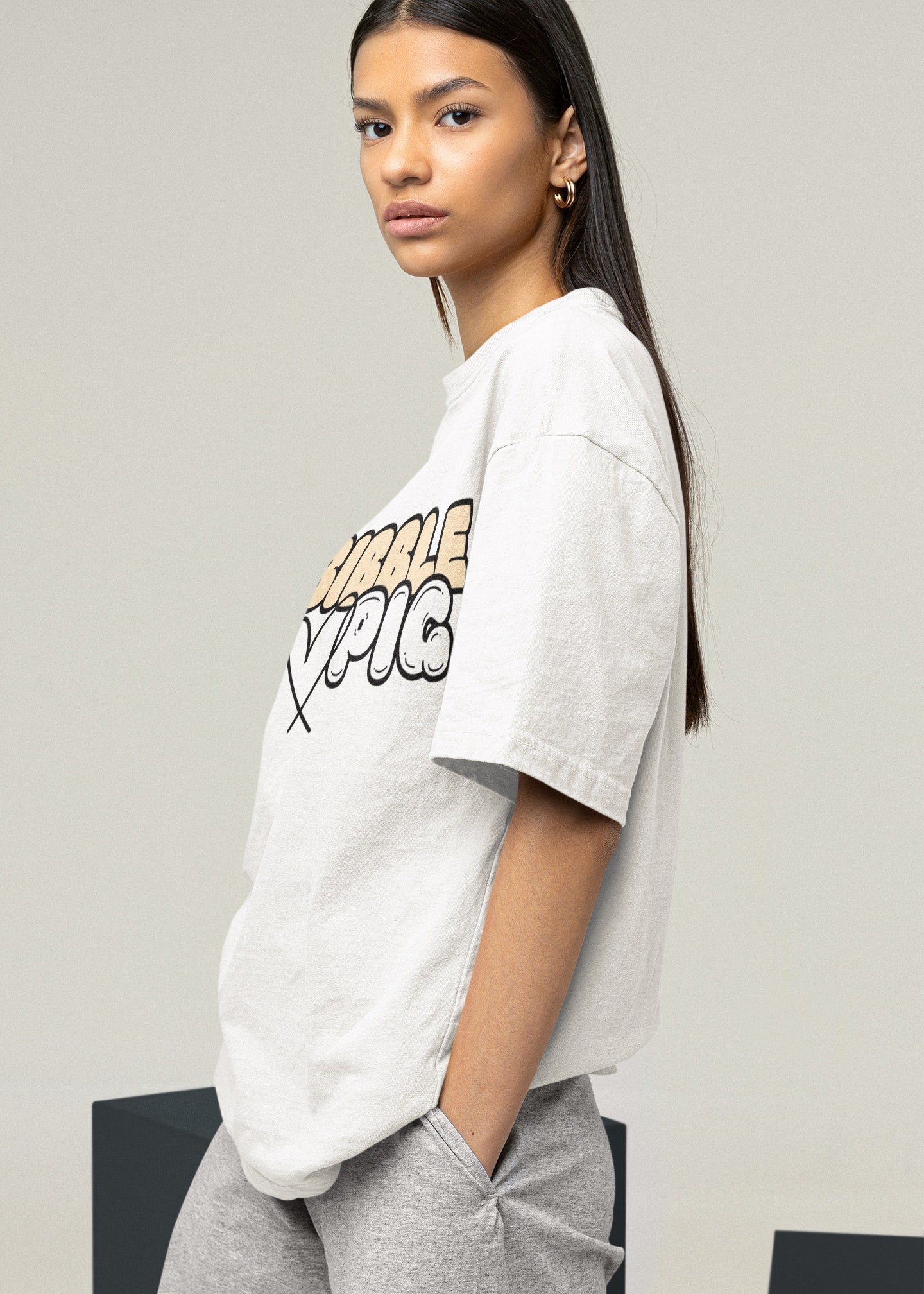 Side view of a model wearing a white oversized organic t-shirt with our Vanilla Bold Logo and cute heart design.